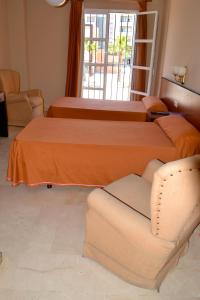 a hotel room with a bed and a chair at Hotel Don Manuel in Algeciras