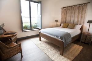 a bedroom with a bed and a large window at The Farmhouse at Meletos in Coldstream