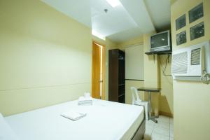 a room with a bed and a table and a tv at GV Hotel - Talisay City in Talisay