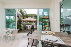 a dining room with a wooden table and chairs at Vacation Time House in Nai Yang Beach