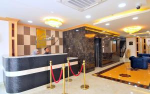 a man standing at a counter in a hotel lobby at Al Afiah Hotel in Bandar Seri Begawan