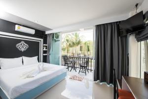 a bedroom with a bed and a balcony at Vacation Time House in Nai Yang Beach