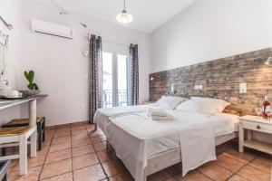 a bedroom with a large bed and a brick wall at Madaky Hotel in Naousa