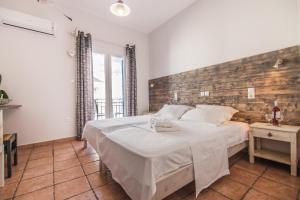 a bedroom with a large bed with a wooden wall at Madaky Hotel in Naousa