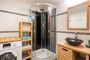 a shower in a bathroom with a sink and a washing machine at Fleur d'eau in Montperreux