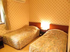 Postel nebo postele na pokoji v ubytování Nikko Pension L'escale