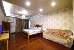 un soggiorno con un letto e un divano di Chi Chi B&B a Tainan