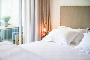 sypialnia z łóżkiem z białą pościelą i oknem w obiekcie Collection Luxury Apartment - 7 On Murray Unit 3 w mieście Stellenbosch