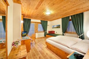 a bedroom with a bed and a desk at Hotel Duc De Rohan in Livigno