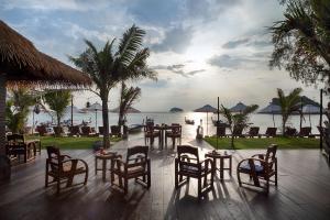 eine Terrasse mit Tischen und Stühlen vor dem Meer in der Unterkunft Mali Resort Sunrise Beach in Ko Lipe
