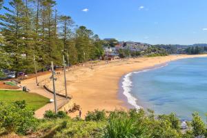 a beach with people on it and the ocean at Joy's Hideaway in Terrigal