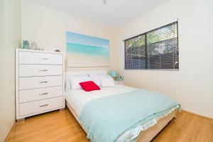 a bedroom with a bed and a dresser and a window at Joy's Hideaway in Terrigal