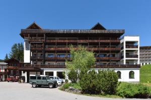 a building with a green truck parked in front of it at Hotel Seehof-Arosa in Arosa