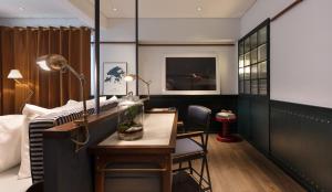 una camera d'albergo con scrivania e tavolo con un pesce in un barattolo di The Fleming Hong Kong a Hong Kong