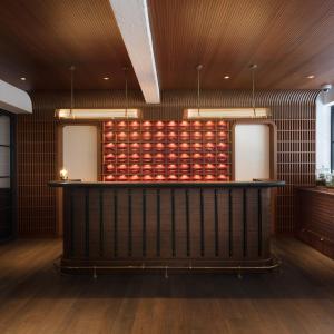 a bar in a room with a wall of apples at The Fleming Hong Kong in Hong Kong