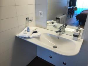 a bathroom with a sink and a mirror at Schüür Restaurant & Kultur in Steffisburg +11 photos