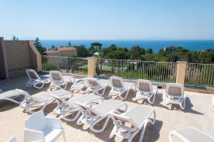 a group of white chairs sitting on a patio at Sisters Hostel in Piano di Sorrento
