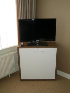 a flat screen tv on top of a white cabinet at Hotel Excelsior in The Hague