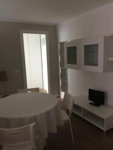 Habitación blanca con mesa y sillas blancas en Appartamento Galileo, en Seregno