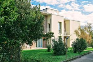 a building with a green yard in front of it at Residence San Rossore in Pisa
