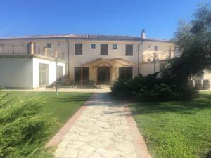 una gran casa blanca con un patio de césped en Villa Loreto, en Alghero