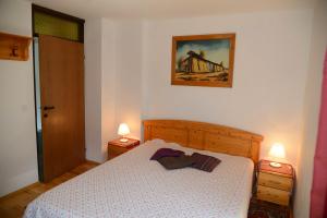 a bedroom with a white bed and two lamps at Apartmaji Rabič in Bohinj