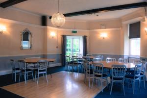 a room with tables and chairs and a chandelier at The Old Down Inn in Radstock