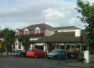 two cars parked in a parking lot in front of a store at Anno Santo Hotel in Galway