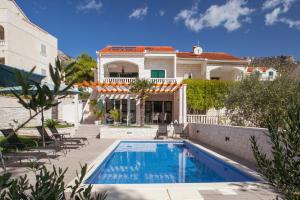 a villa with a swimming pool in front of a house at BOLero in Bol