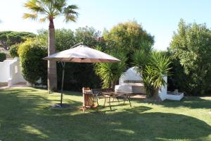 an umbrella and a table and chairs in a yard at Villa Alizée B&B in Saint-Tropez