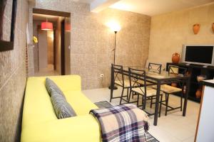 a living room with a yellow couch and a table at Casa da Avó in Elvas