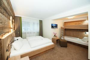 1 Schlafzimmer mit 2 Betten und 1 Etagenbett in der Unterkunft Hotel Birkenhof in Saalbach-Hinterglemm