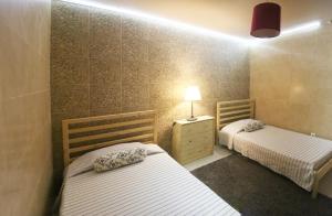 a room with two beds and a lamp in it at Casa da Avó in Elvas