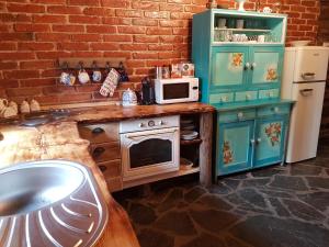 a kitchen with a counter with a stove and a microwave at Stodola Sonja in Lúčky