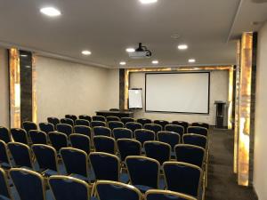 a conference room with a white screen and chairs at Premier Hotel Center in Voronezh