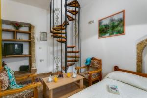 salon z łóżkiem i spiralnymi schodami w obiekcie Ifigenia Rooms w Chanii