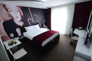 Postel nebo postele na pokoji v ubytování Garni Hotel Hollywoodland Wellness & Aquapark