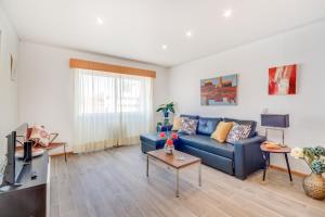 ein Wohnzimmer mit einem blauen Sofa und einem TV in der Unterkunft Cosmopolis in Lissabon