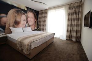 Postel nebo postele na pokoji v ubytování Garni Hotel Hollywoodland Wellness & Aquapark