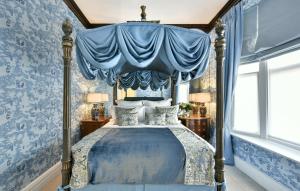 a blue bedroom with a bed with a canopy at San Domenico House in London