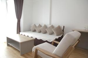 Hotel Korab Trnica في Trnica: أريكة بيضاء مع وسائد وكرسي في الغرفة