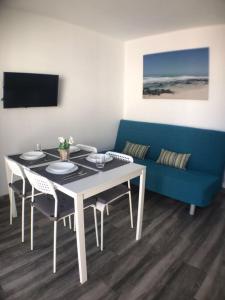 a dining room with a table and a blue couch at Apartment Enjoy Corralejo in Corralejo