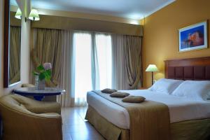 a hotel room with a bed and a chair at Ariti Grand Hotel in Corfu