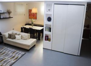 GiaVa Apartment في بارونيسي: غرفة معيشة مع أريكة بيضاء وطاولة