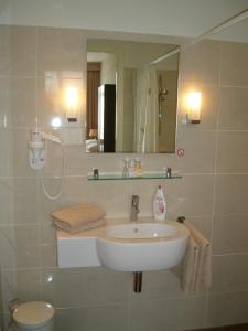 a bathroom with a sink and a toilet and a mirror at Hotel Excelsior in The Hague