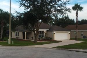 a house with a palm tree and a driveway at Villa Dunes Court in Haines City