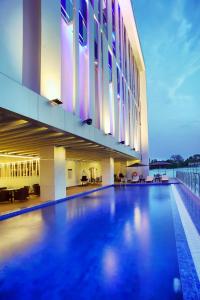 a large building with a swimming pool in front of it at Golden Tulip Essential Makassar in Makassar