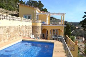 a villa with a swimming pool in front of a house at Zoro LOCDENIA in Denia