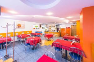 a restaurant with red tables and chairs in a room at Hostel Brize in Liepāja