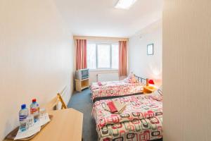 a hotel room with two beds and a table at Hostel Brize in Liepāja
